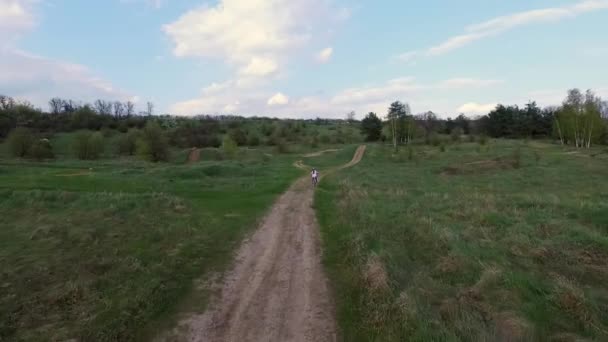 Niña paseos en bicicleta en la carretera del campo — Vídeos de Stock