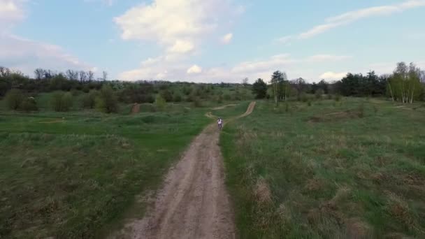 Little girl rides bicycle on country road — Stock Video