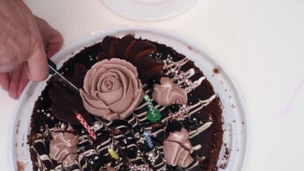Жінка рука ріже торт на день народження зі свічками — стокове відео