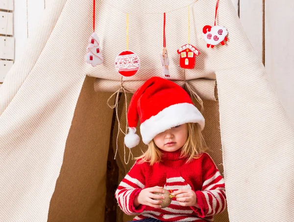 Bonito menina no vermelho chapéu com brinquedo-bola em mãos perto wigwam — Fotografia de Stock