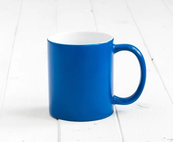 Blaue Tasse mit weißem Inneren auf Holztisch — Stockfoto