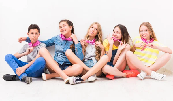 Cute smiling tenagers sitting on the floor — Stock Photo, Image
