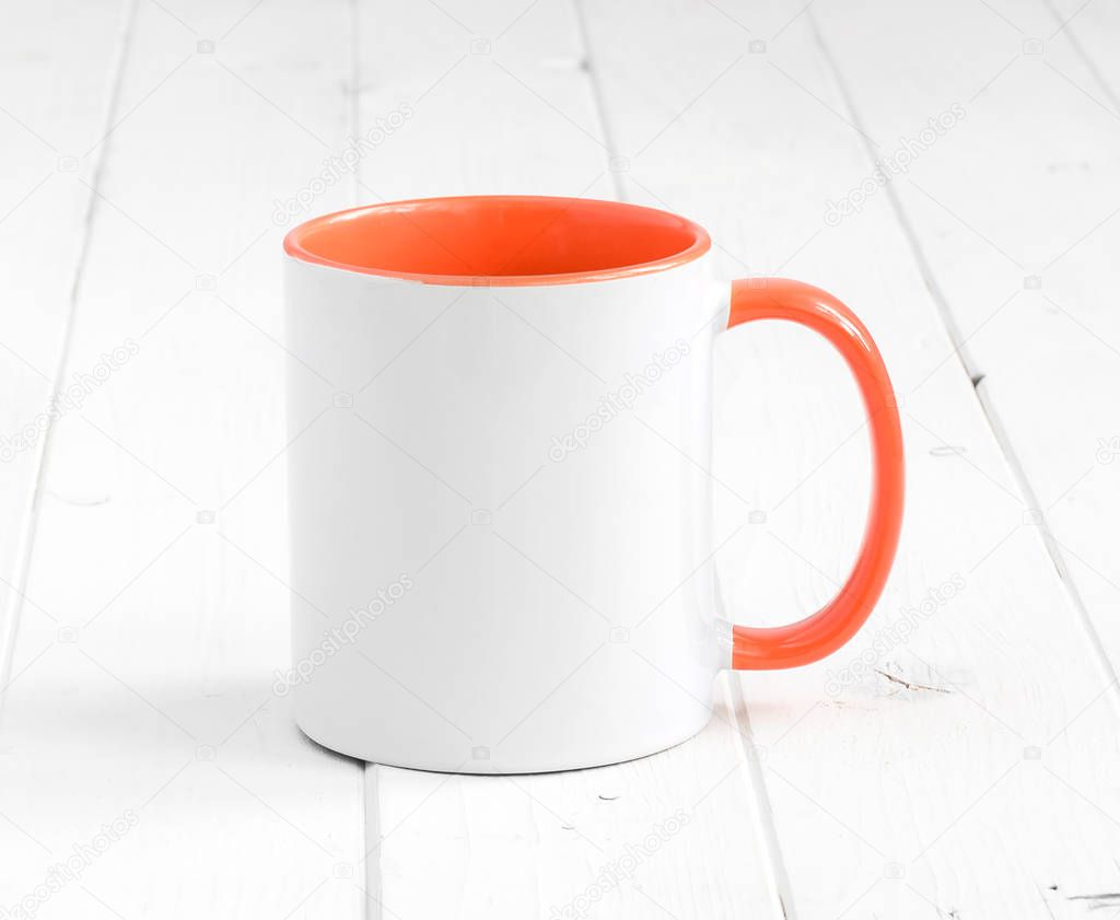 white cup with dark orange inside on a table