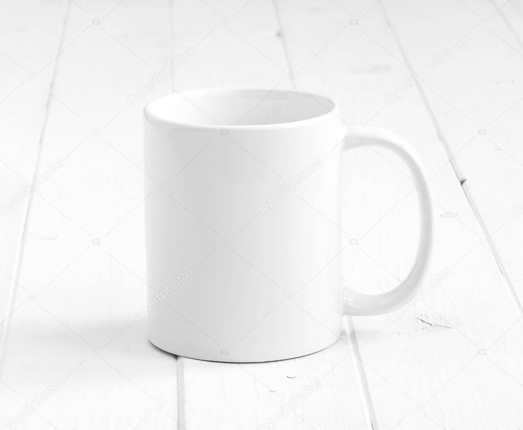 white empty cup on planked surface