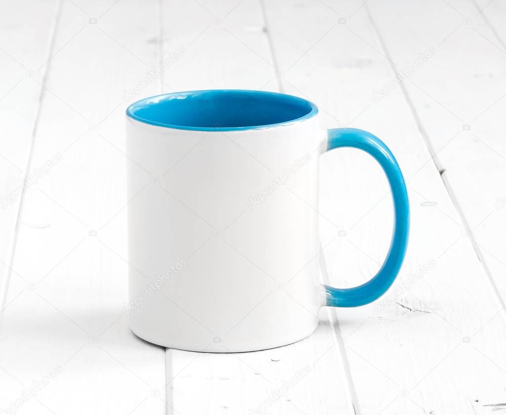 white cup with dark blue inside on a table