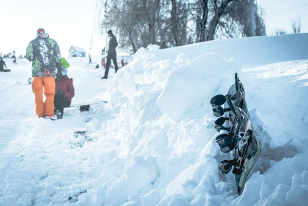 Snowboard sdraiato sul cumulo di neve sulla collina — Foto Stock