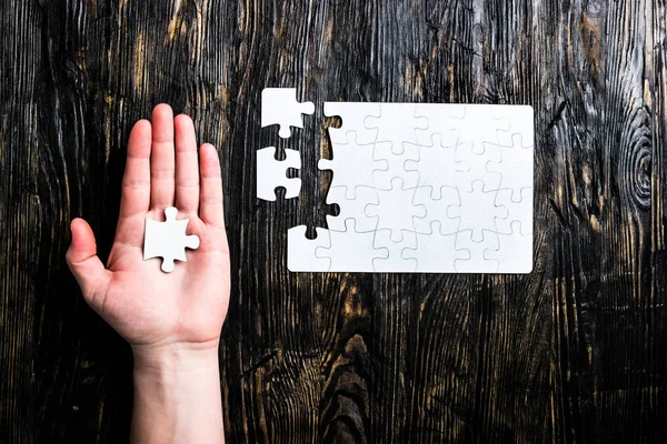 Hand with white puzzle — Stock Photo, Image