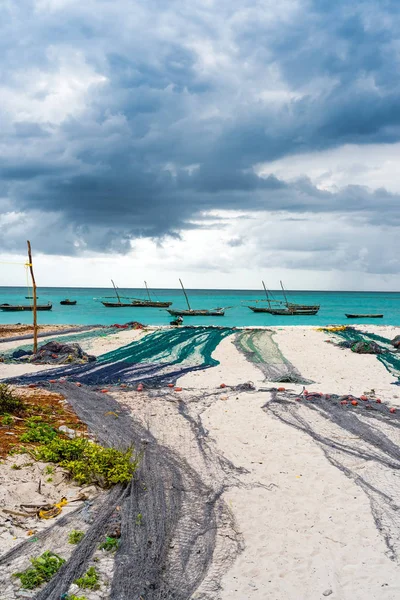Προβολή της μεγάλα αλιευτικά δίχτυα σε μια ακτή με ωκεανό και βάρκες στο παρασκήνιο — Φωτογραφία Αρχείου