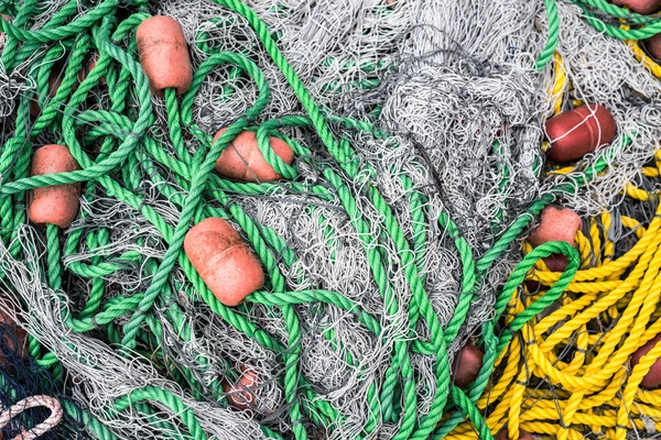 Pile of fishing nets with floats and colorful ropes — Stock Photo, Image