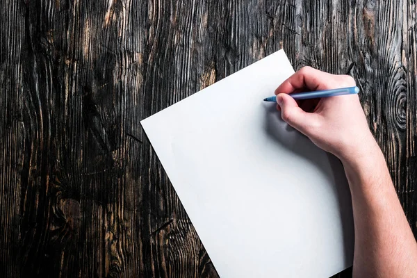 Hand mit Stift und weißem Blankoblatt auf dem Tisch — Stockfoto