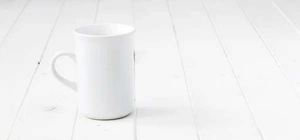 Biały pusty kubek na biały stół — Zdjęcie stockowe
