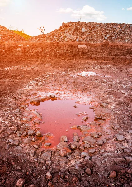 Flaque d'eau sur un sol pierreux rouge — Photo