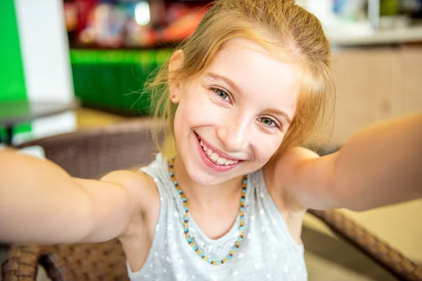 Usmívající se legrační malá holčička dělá selfie — Stock fotografie