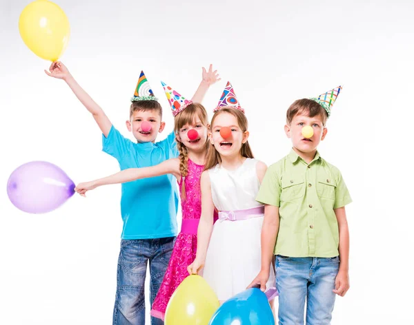 Enfants drôles avec nez de clown et chapeaux d'anniversaire — Photo