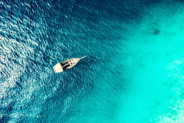 Água azul-turquesa do oceano com barco sobre ele vista superior — Fotografia de Stock