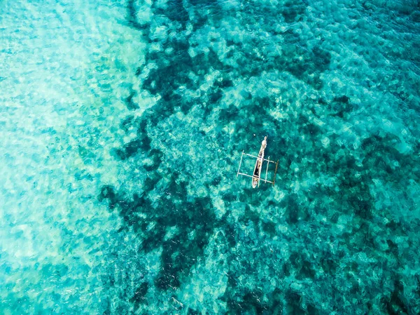 Barco africano solitário em claro oceano azul-turquesa — Fotografia de Stock