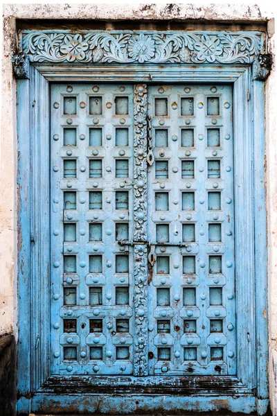 Big carved wooden door with peeling paint — Stock Photo, Image