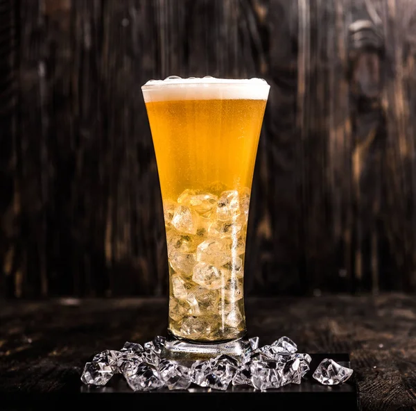 Vidro de cerveja leve com gelo e espuma — Fotografia de Stock