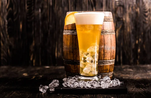 Barril e copo de cerveja leve com gelo e limão — Fotografia de Stock