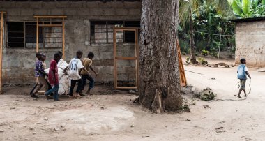 bir çuval sürükleyerek küçük Afrikalı erkek grup