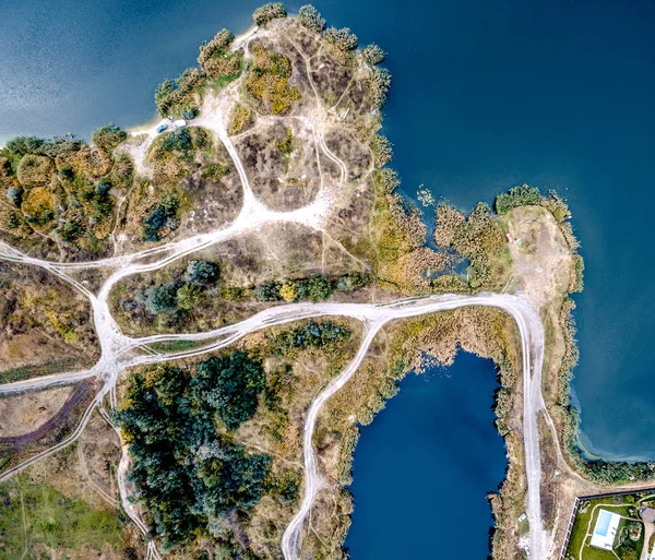 Connected pieces of land with rolled tracks and lakes on sides — Stock Photo, Image