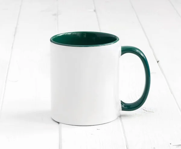 Taza blanca con interior verde sobre fondo de madera —  Fotos de Stock