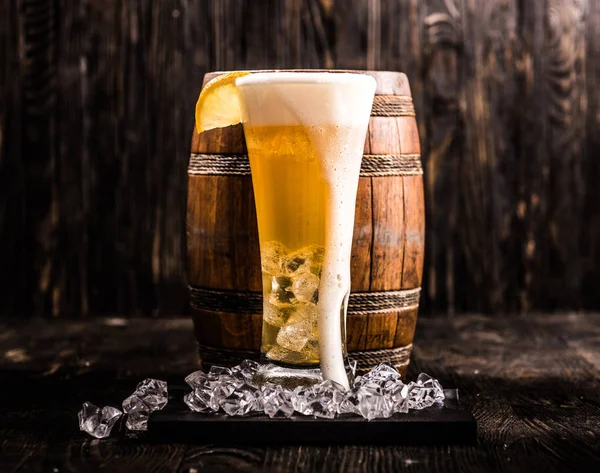 Barril e copo de cerveja leve com gelo e limão — Fotografia de Stock