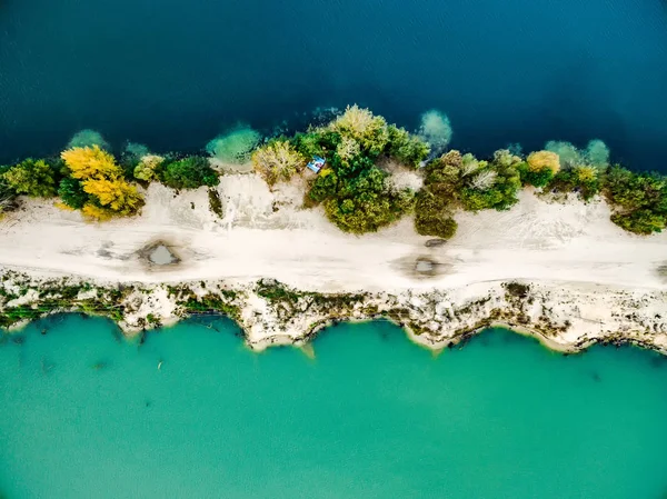 Sandy shore with colourful water — Stock Photo, Image