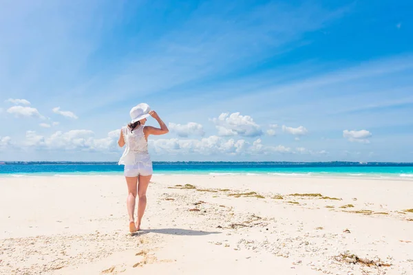 Belle fille souriante en chapeau sur une plage — Photo