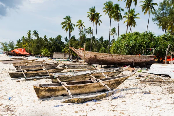 Písečná pláž rybářská vesnice s dřevěnými loděmi v Zanzibar — Stock fotografie