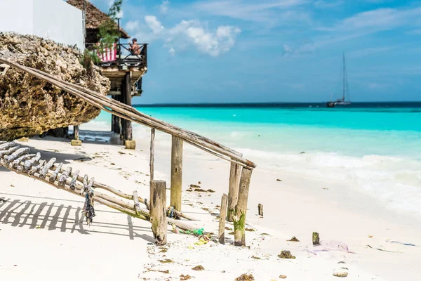 Beautiful ocean beach with wooden footway and a hut — Stock Photo, Image