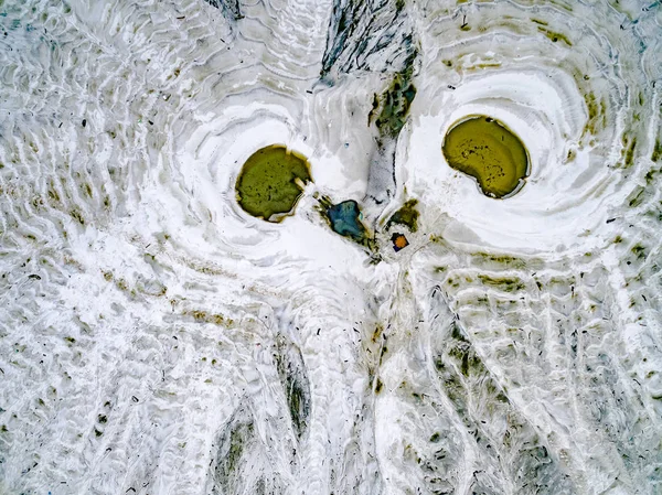 Abstract patterns on the ground from water streams resembling ow — Stock Photo, Image