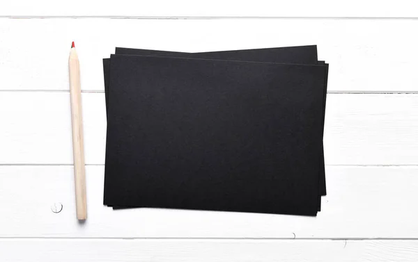 Stack av svart papper med penna — Stockfoto