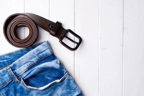 Manliga jeans och bältet på trä bakgrund — Stockfoto