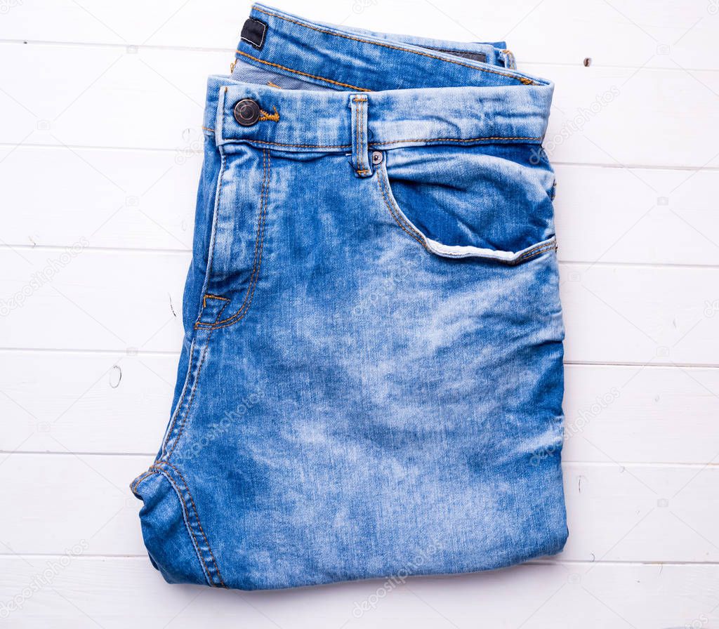 blue folded jeans on wooden background