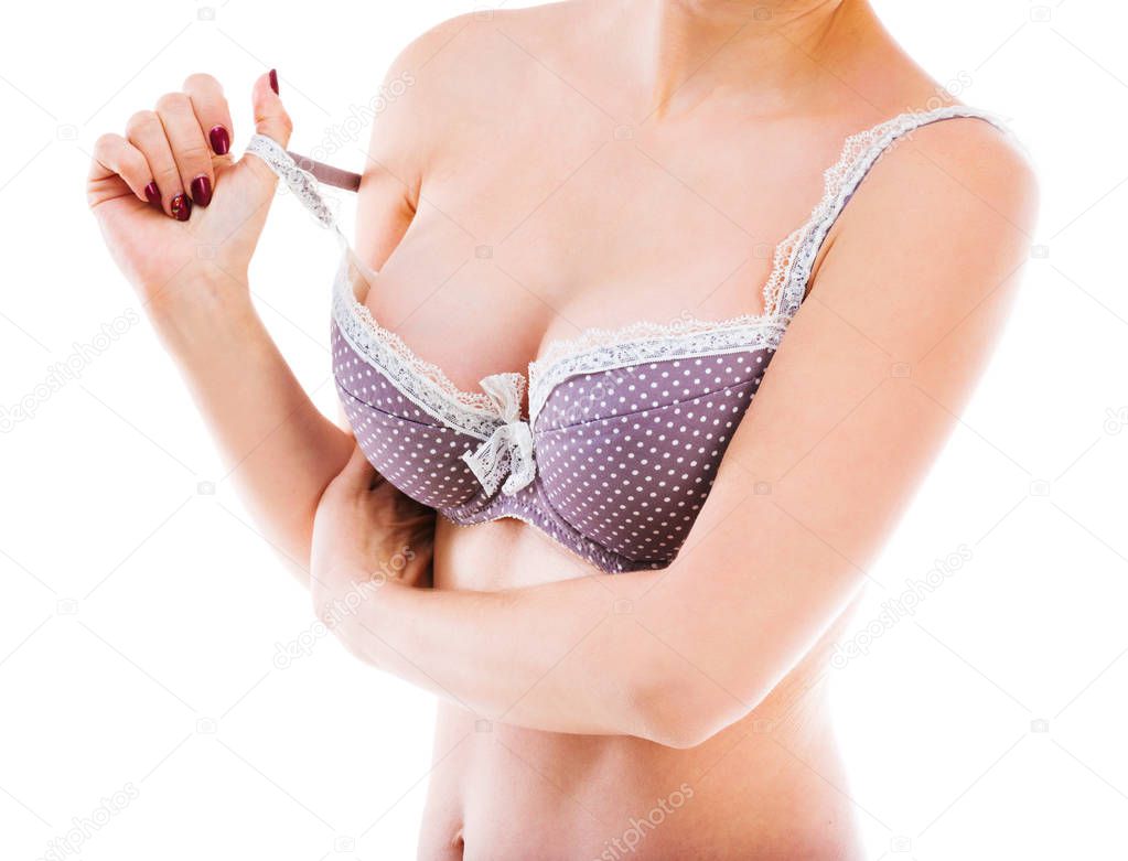 Fit woman playing with bra strap, isolated