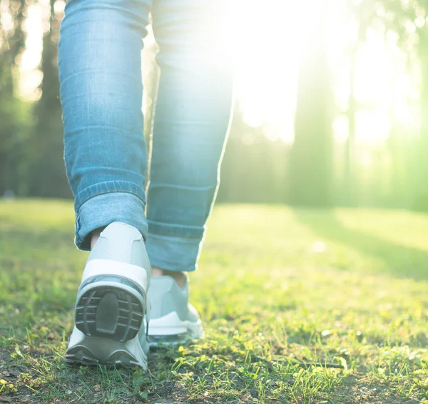 Caminhando em sapatos de corrida cinza, de volta para a câmera — Fotografia de Stock