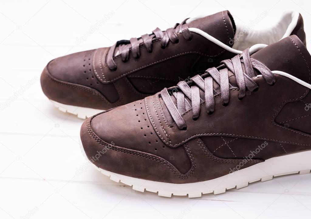 brown leather shoes with laces on wooden background