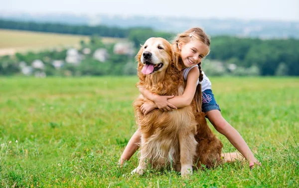 Liten flicka med golden retriever — Stockfoto