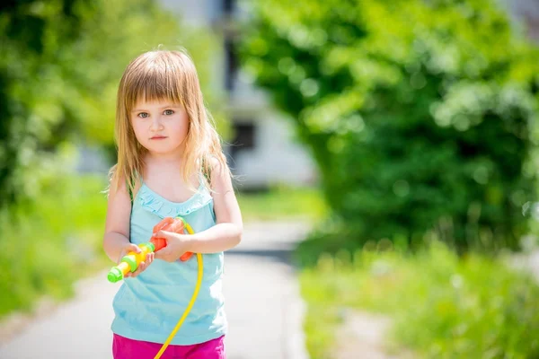 Kleines Mädchen schießt mit Wasserpistole — Stockfoto