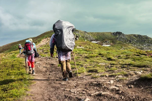 Tres excursionistas caminando por las montañas — Foto de Stock