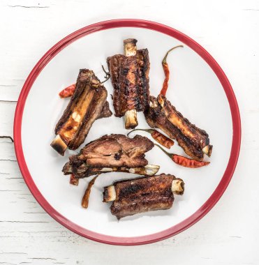 Domuz kaburga beyaz tabakta, üstten görünüm.