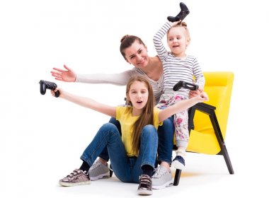 Anne ve iki kızı joystick ile oyun oynamak