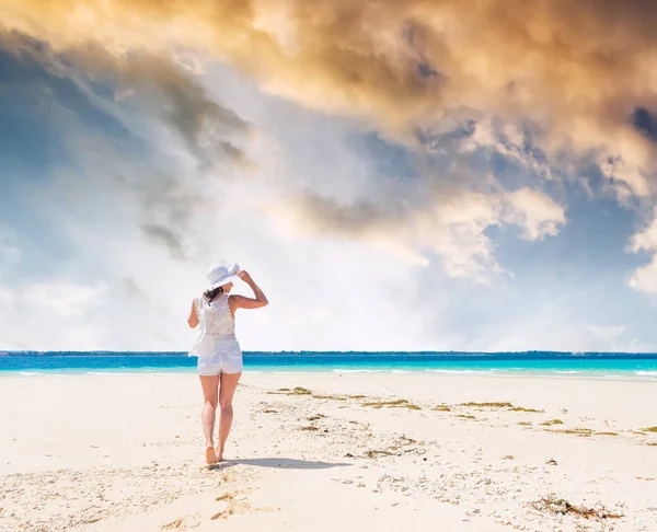 Belle fille souriante en chapeau sur une plage — Photo