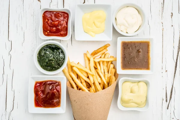 Patatine fritte con salse su sfondo bianco, vista dall'alto — Foto Stock