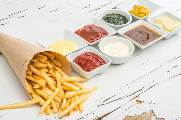 Patatine fritte con salse su sfondo bianco, vista dall'alto — Foto Stock