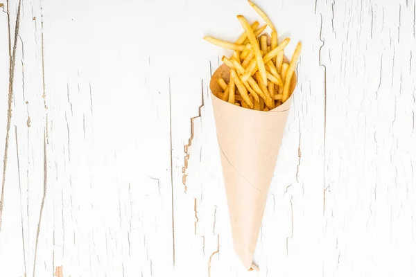 Batatas fritas embrulhadas em papel sobre fundo branco — Fotografia de Stock