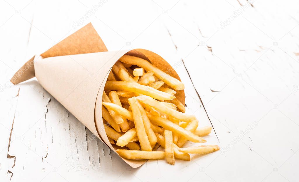 French fries wrapped in paper on white background