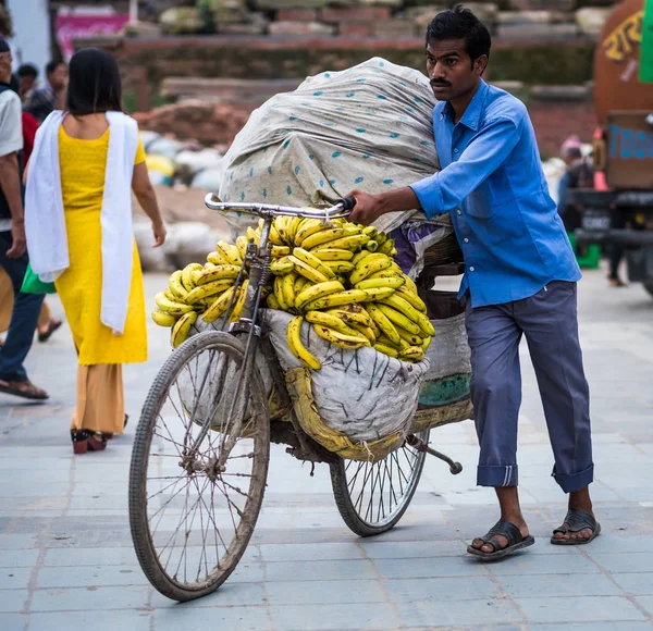 El hombre vende plátanos en una bicicleta en un mercado callejero — Foto de Stock