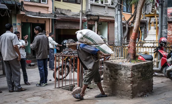 Мужчина носит мешок на спине на улицах Катманду. — стоковое фото